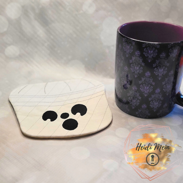 Halloween Pail Ghost Mug Rug shown next to cup