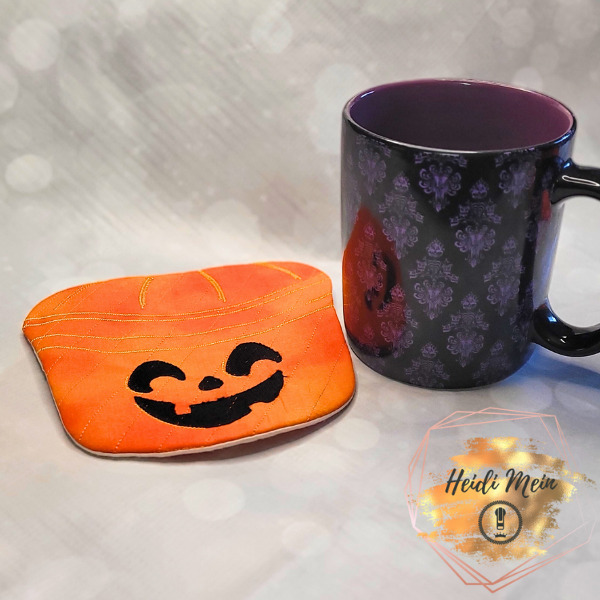 Halloween Pail Pumpkin Mug Rug shown next to cup